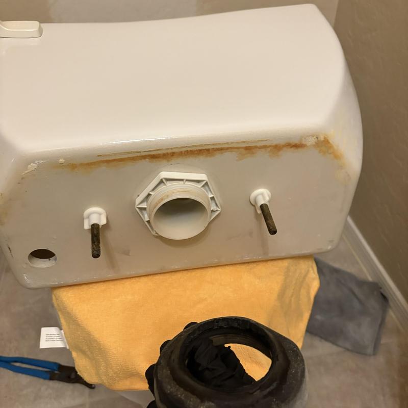 Toilet tank with rust stains and mounting bolts removed