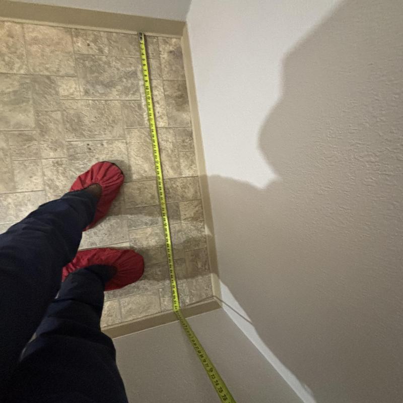 Basement bathroom flooring with measuring tape Basement bathroom flooring with measuring tape