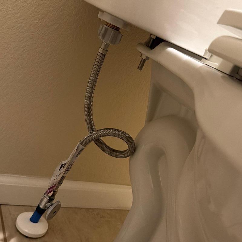 Toilet supply line and fill valve installation close-up Toilet supply line and fill valve installation close-up