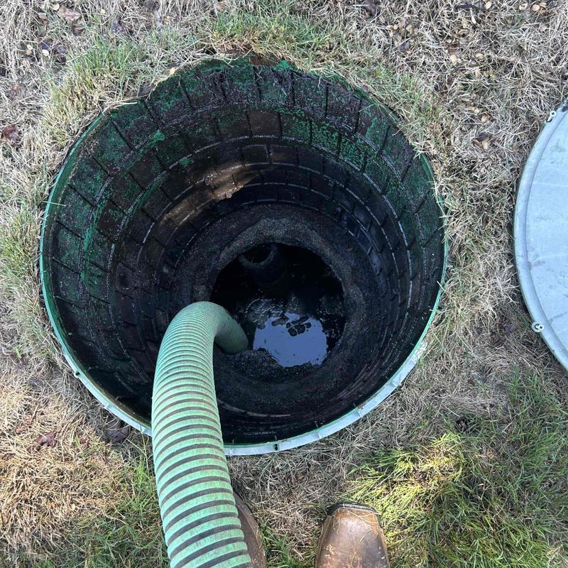 Septic tank riser with vacuum hose in grass Septic tank riser with vacuum hose in grass