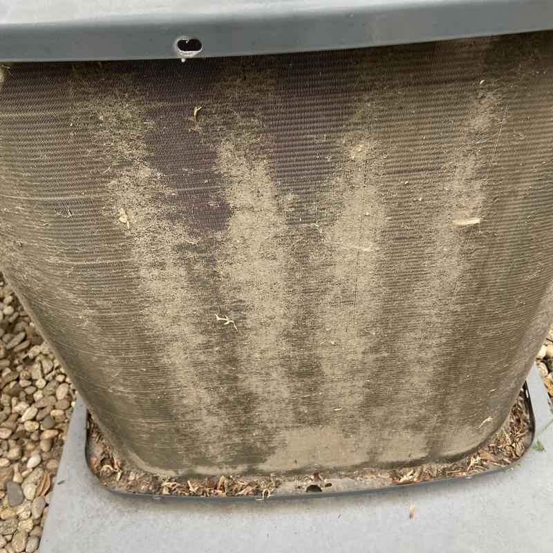 Condenser coil clogged with dirt and debris outdoors Condenser coil clogged with dirt and debris outdoors