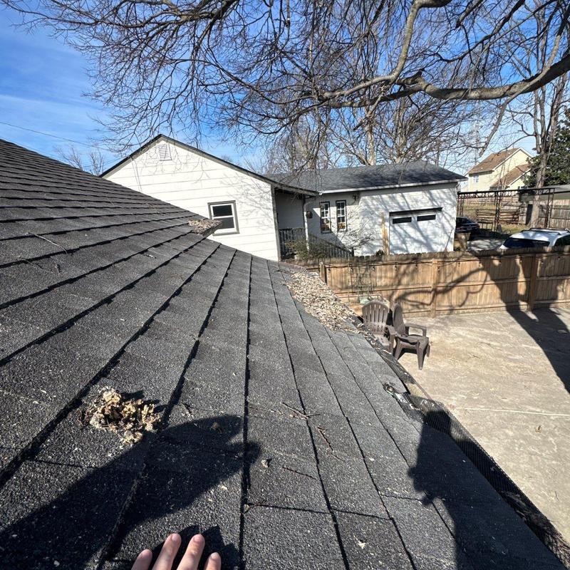 Asphalt roof shingles with hail damage and debris