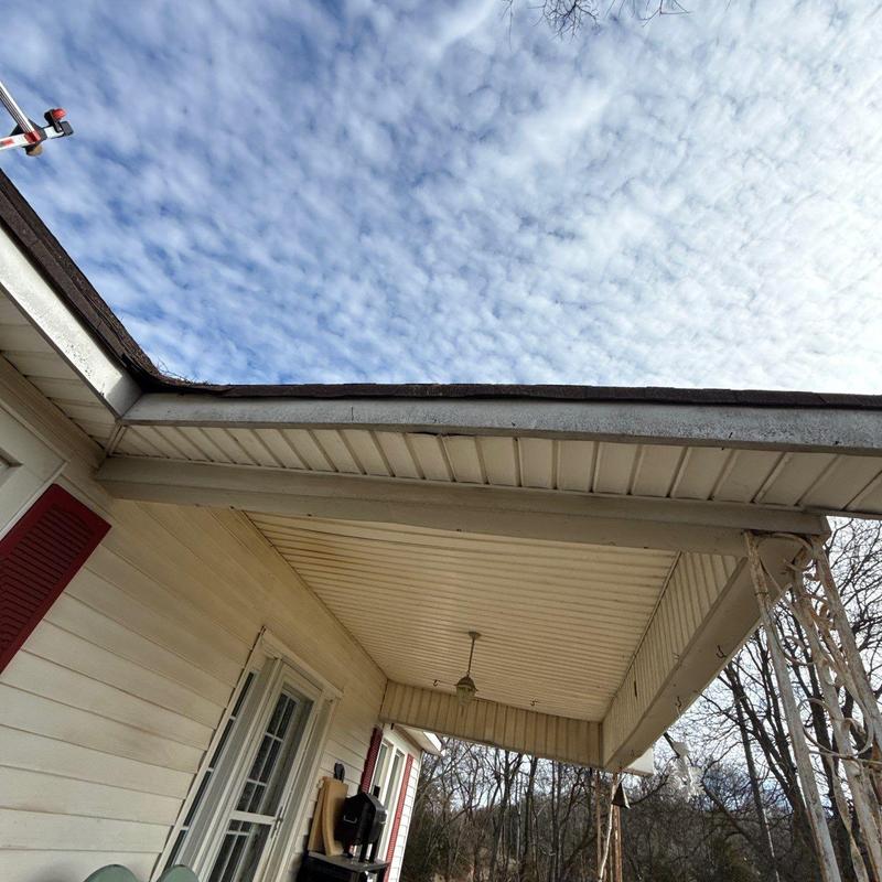 Roof edge and soffit inspection under cloudy sky