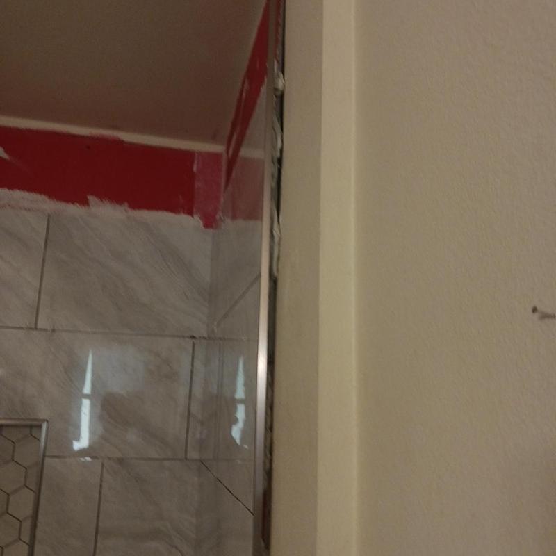 Shower tile edge with damaged grout and wall gap