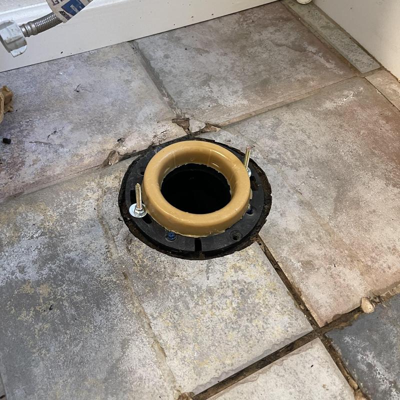 Toilet flange installed and anchored on tiled floor