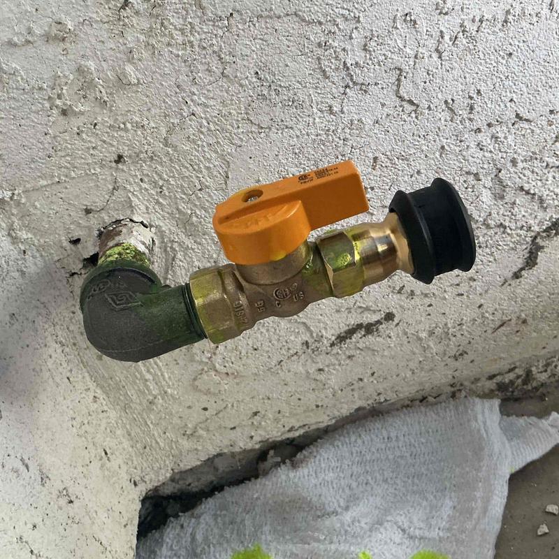 Gas valve with orange handle on exterior wall
