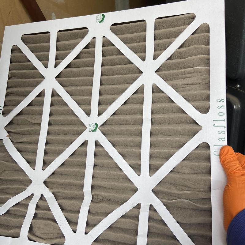 Furnace air filter held by gloved hand Furnace air filter held by gloved hand