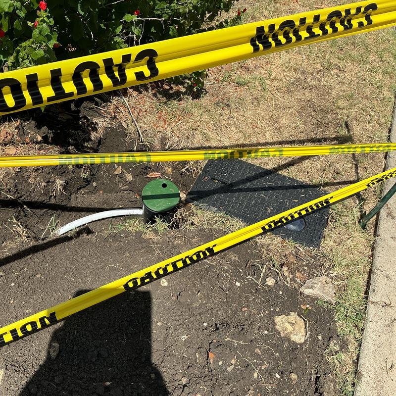PEX yard line with green shutoff valve and caution tape PEX yard line with green shutoff valve and caution tape