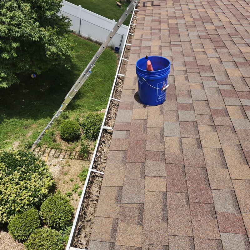 Gutter installation with debris guard on shingled roof