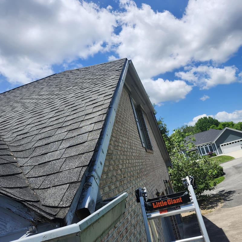 Gutter hanging loose on brick house exterior
