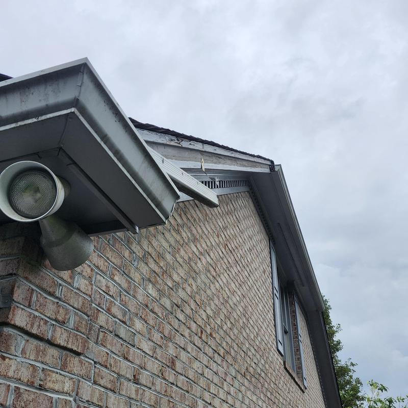 Gutters with detached sections on brick house exterior