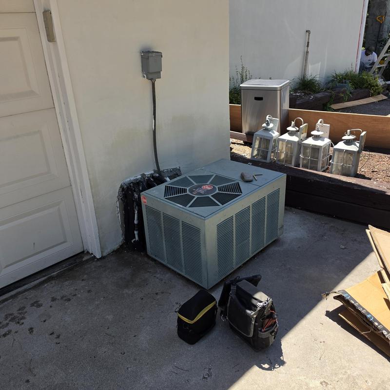 American Standard air conditioner unit by wall outdoors