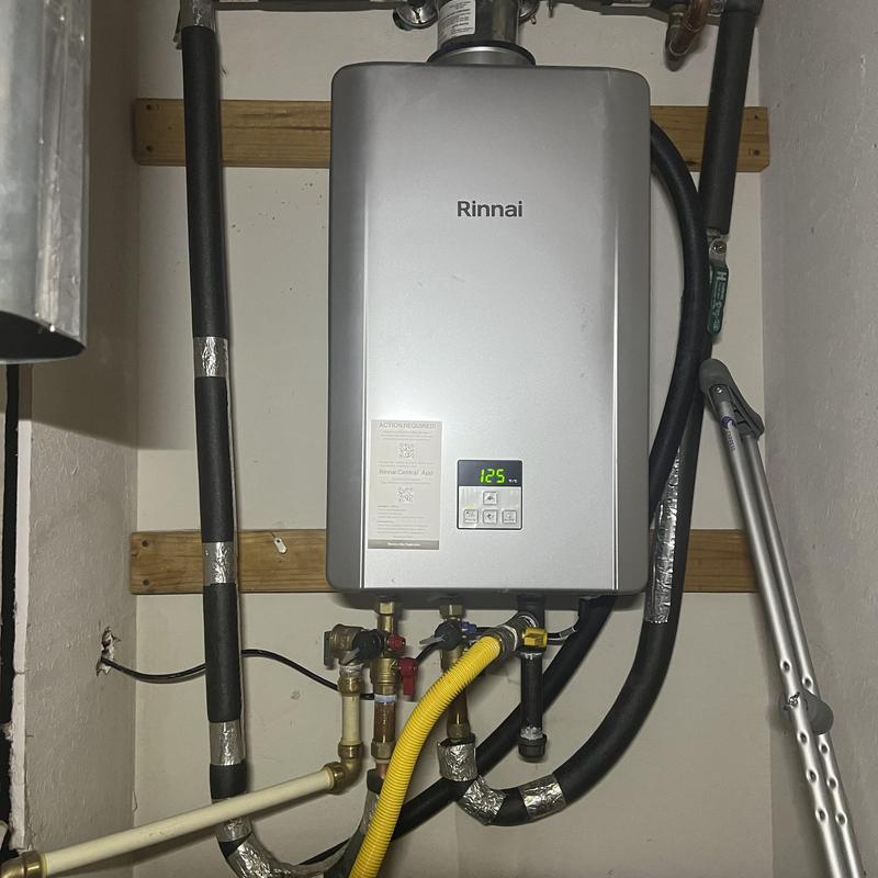 Rinnai tankless water heater with updated plumbing and surge protector
