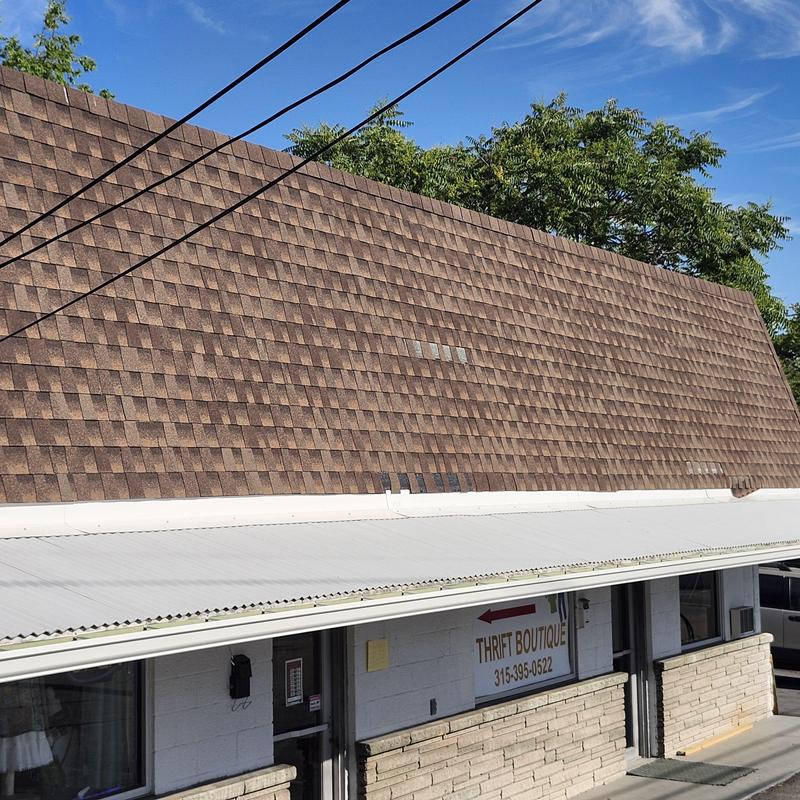 Asphalt shingle roof with metal awning above store entrance