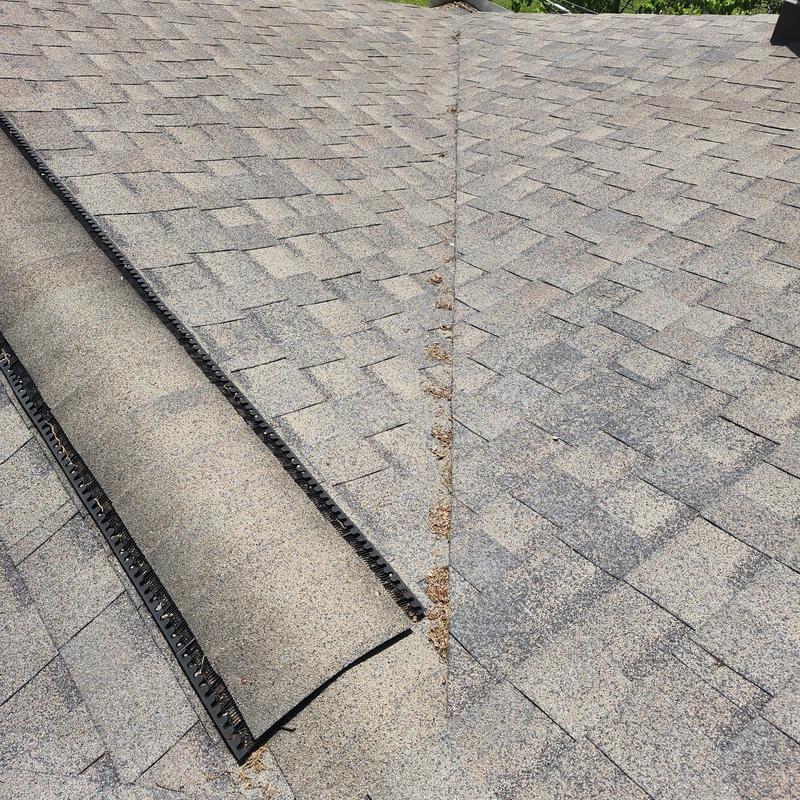 Asphalt shingle roof valley with debris and wear