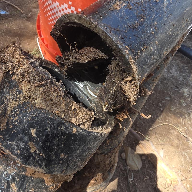 Broken ABS sewer main line with soil debris