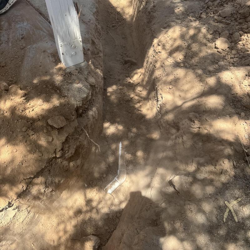 Sewer line trench excavation with exposed pipe in dirt Sewer line trench excavation with exposed pipe in dirt