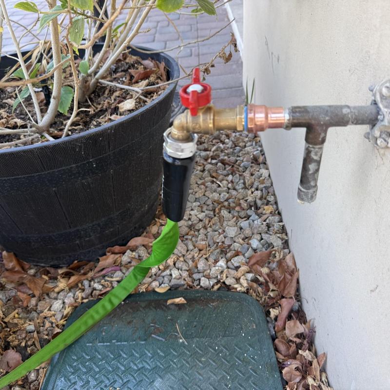 Outdoor hose bib with attached green garden hose