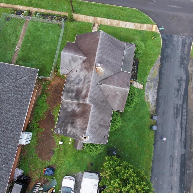Roof shingles with discoloration and stains on house