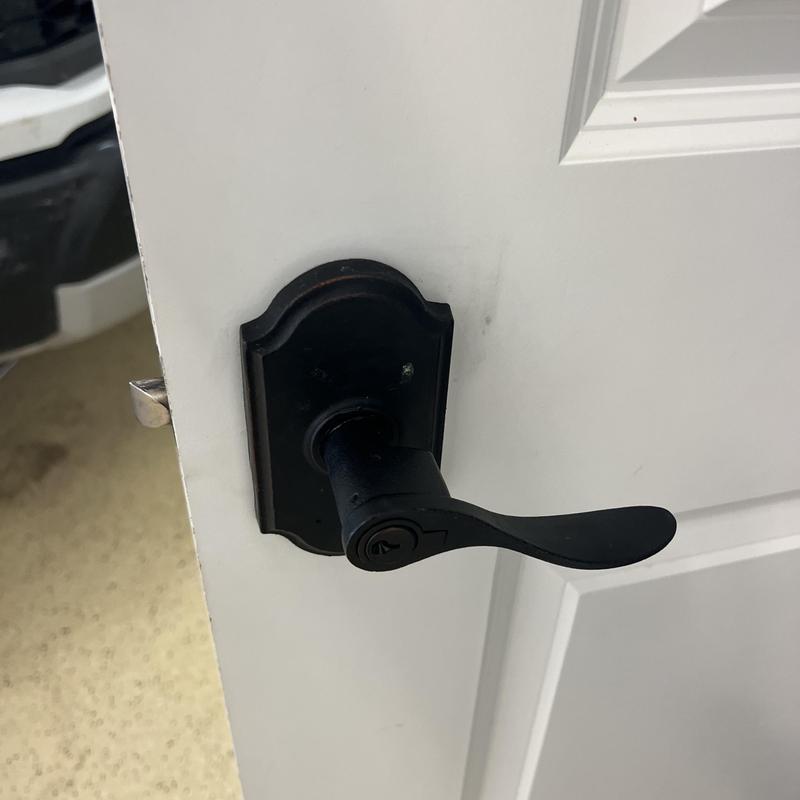 Door lever handle lock on white door in garage
