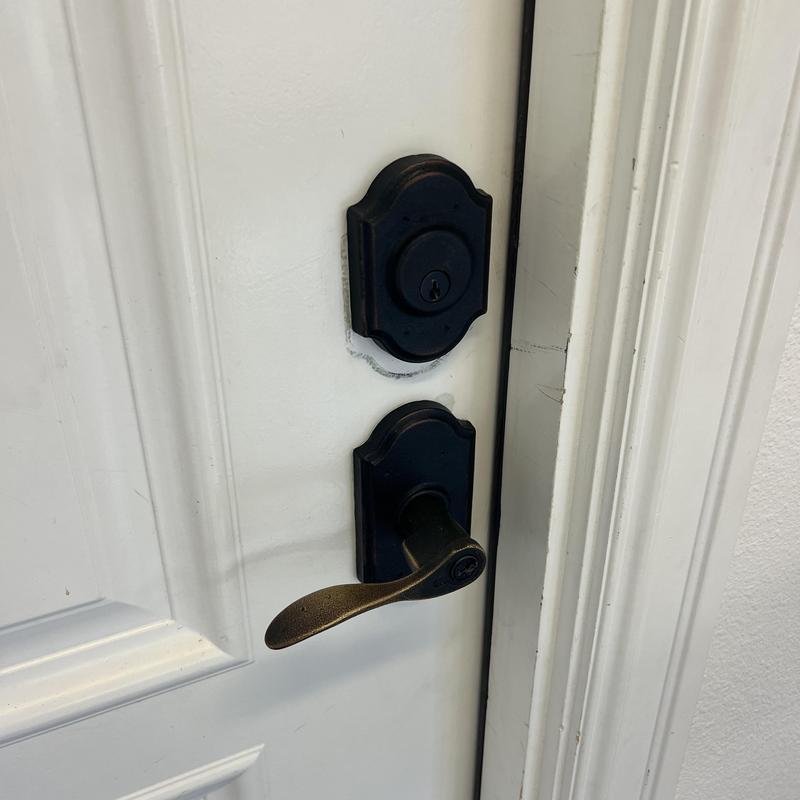 Deadbolt and door handle lock on white entry door