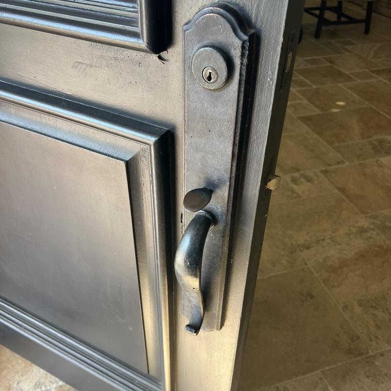Exterior door handle and deadbolt lock on black door