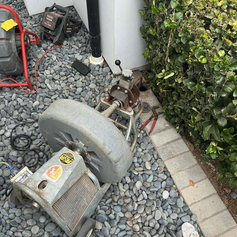 Sewer main drain line with drain cleaning machine