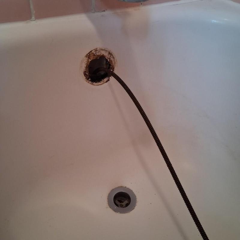 Tub drain cleaning cable inside drainpipe