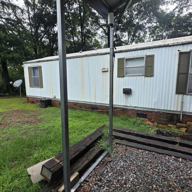 Mobile home exterior with leaking door and gutters