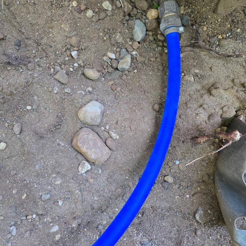 Blue water service pipe with metal fittings underground