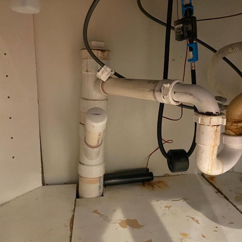 PVC drain pipes with corrosion under sink cabinet PVC drain pipes with corrosion under sink cabinet