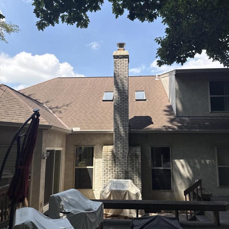 Skylights on residential roof with chimney and patio