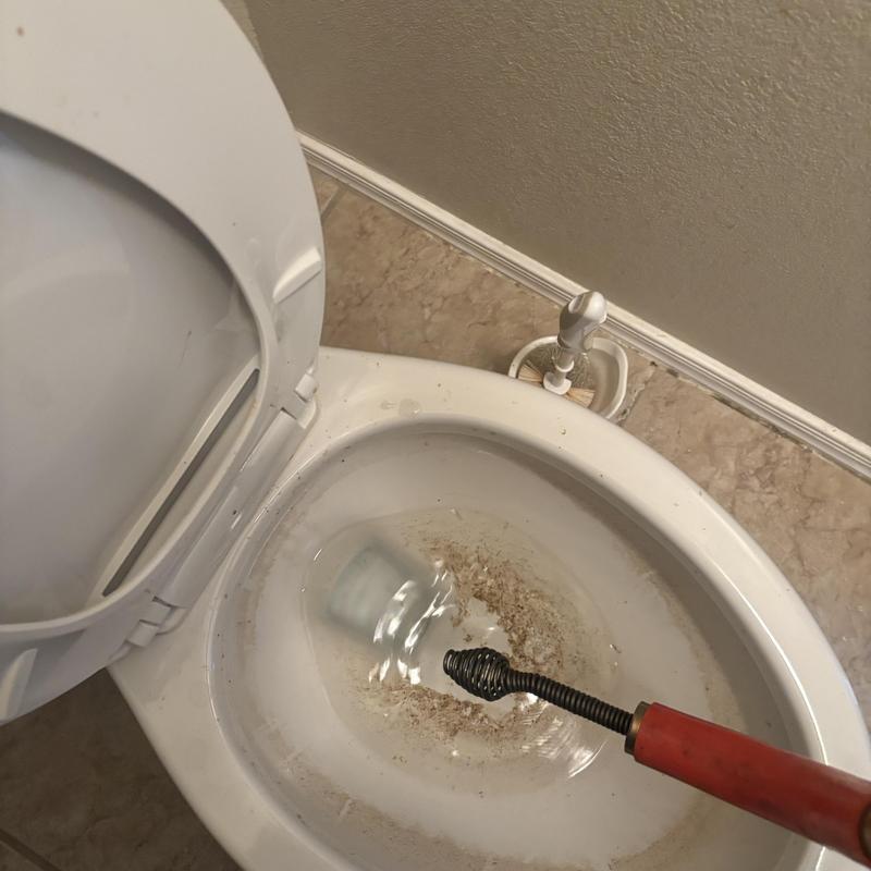 Master bathroom toilet clog removal with plumber snake