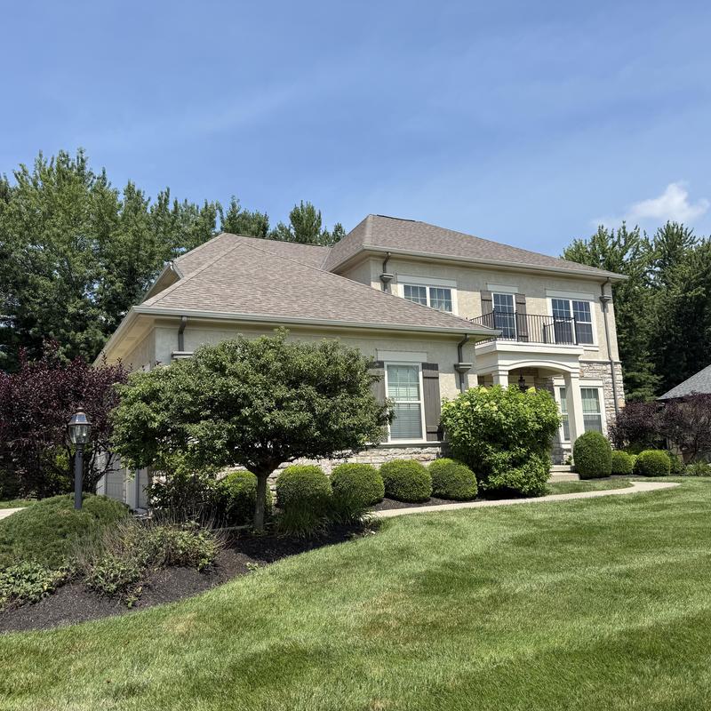 Asphalt shingle roof on two-story house exterior