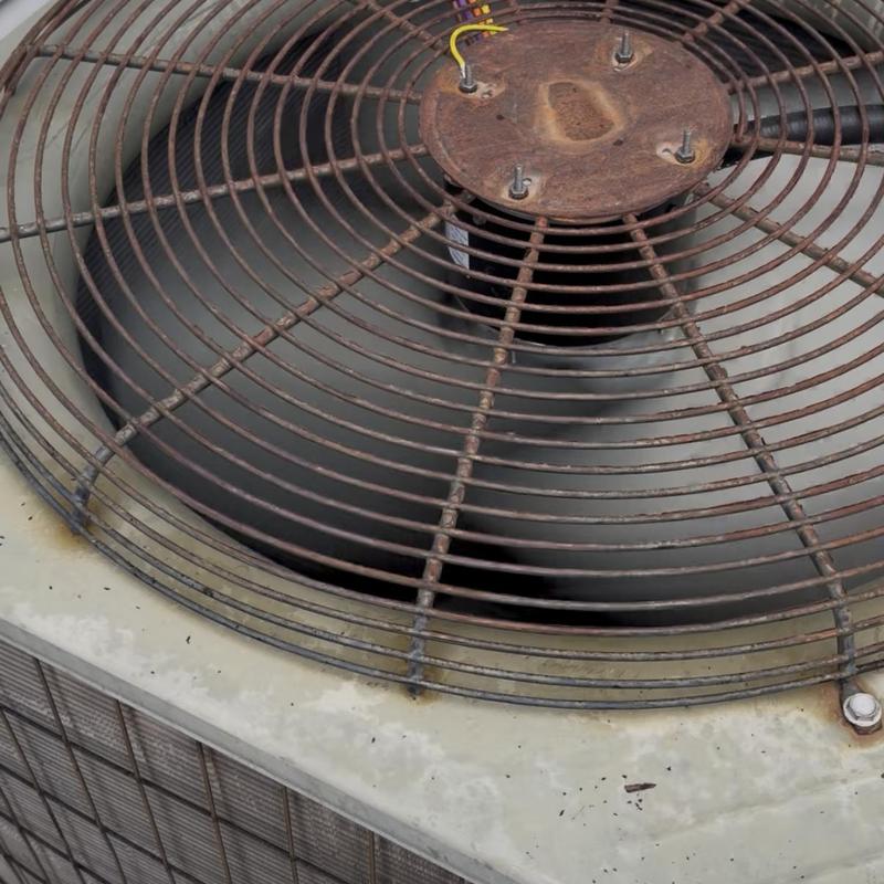 Condenser fan motor on HVAC unit with rusted grill