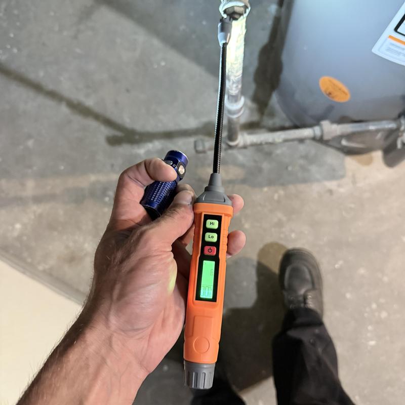 Gas line leak detector near water heater pipe