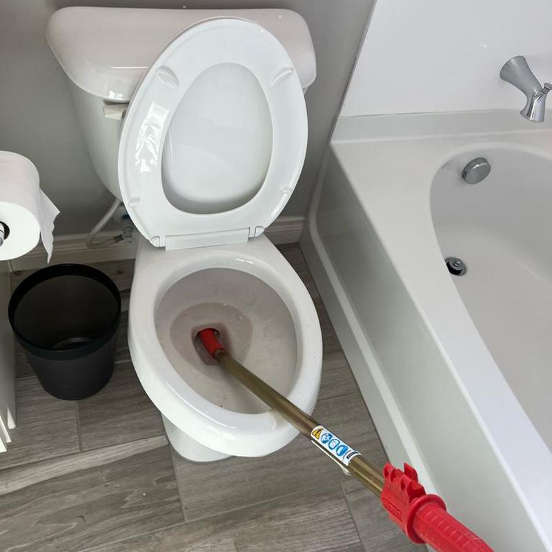 Toilet with auger removing blockage in bathroom Toilet with auger removing blockage in bathroom