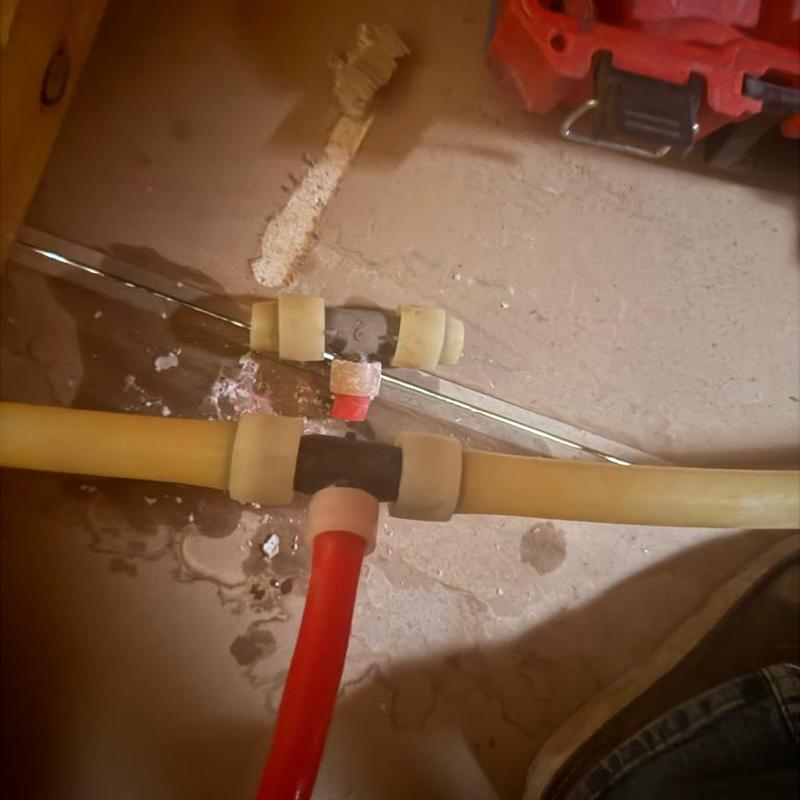 PEX tee fitting with red and yellow tubing connection PEX tee fitting with red and yellow tubing connection