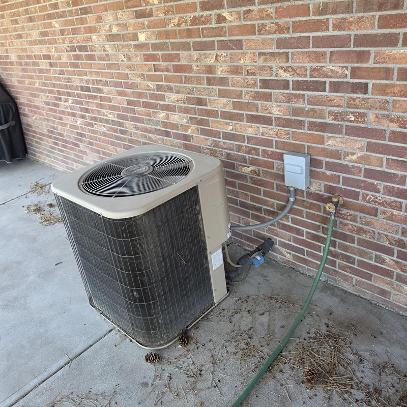 Amana air conditioner unit by brick wall