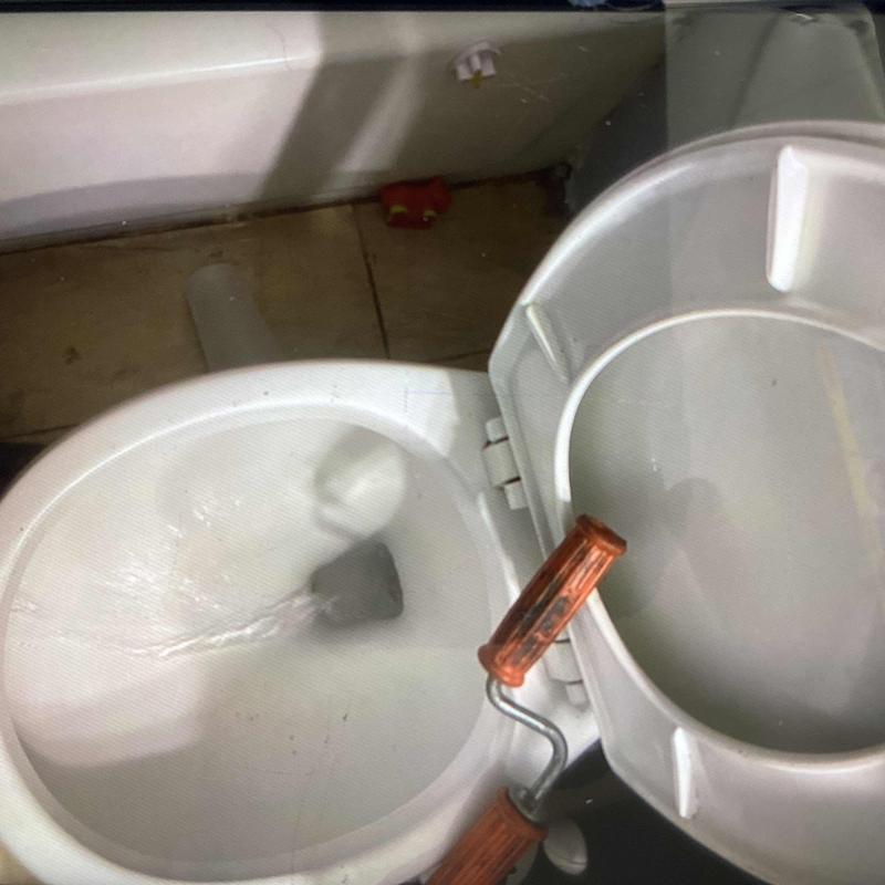 Toilet bowl with auger tool in guest bathroom Toilet bowl with auger tool in guest bathroom