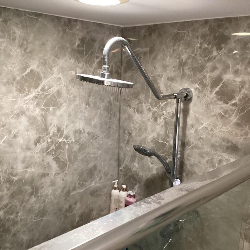 Shower head and arm with water flow in bathroom Shower head and arm with water flow in bathroom