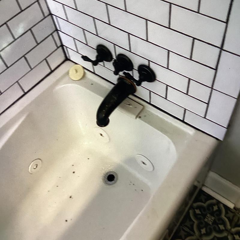Shower valve and faucet in bathtub with white tile wall Shower valve and faucet in bathtub with white tile wall