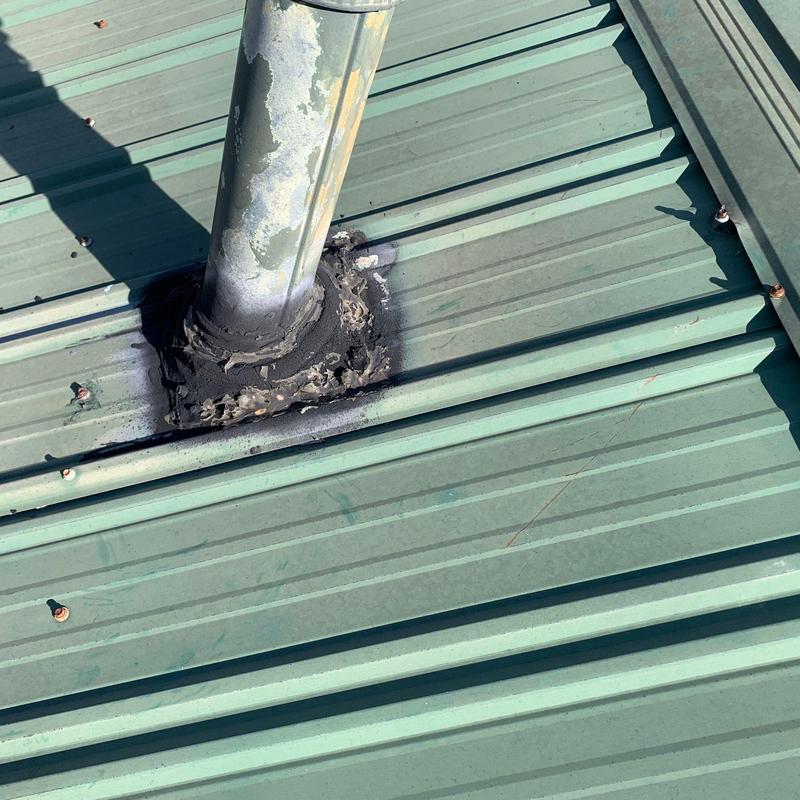 Metal roof pipe flashing with sealant on green panels
