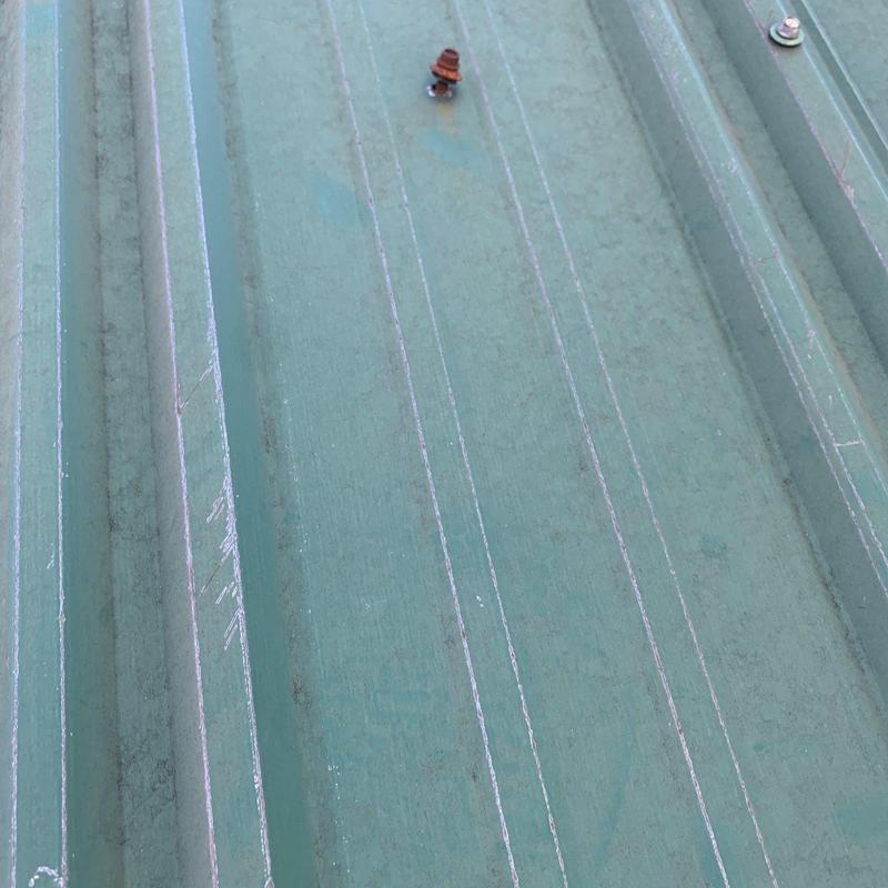 Metal roof hail impact marks and rusted fastener detail
