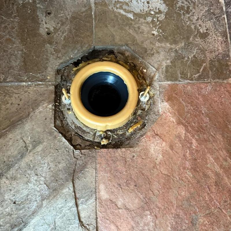 Toilet flange on tiled bathroom floor installation site Toilet flange on tiled bathroom floor installation site