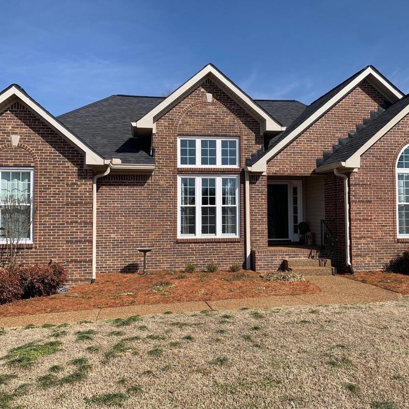 Roof shingles with hail damage on brick house