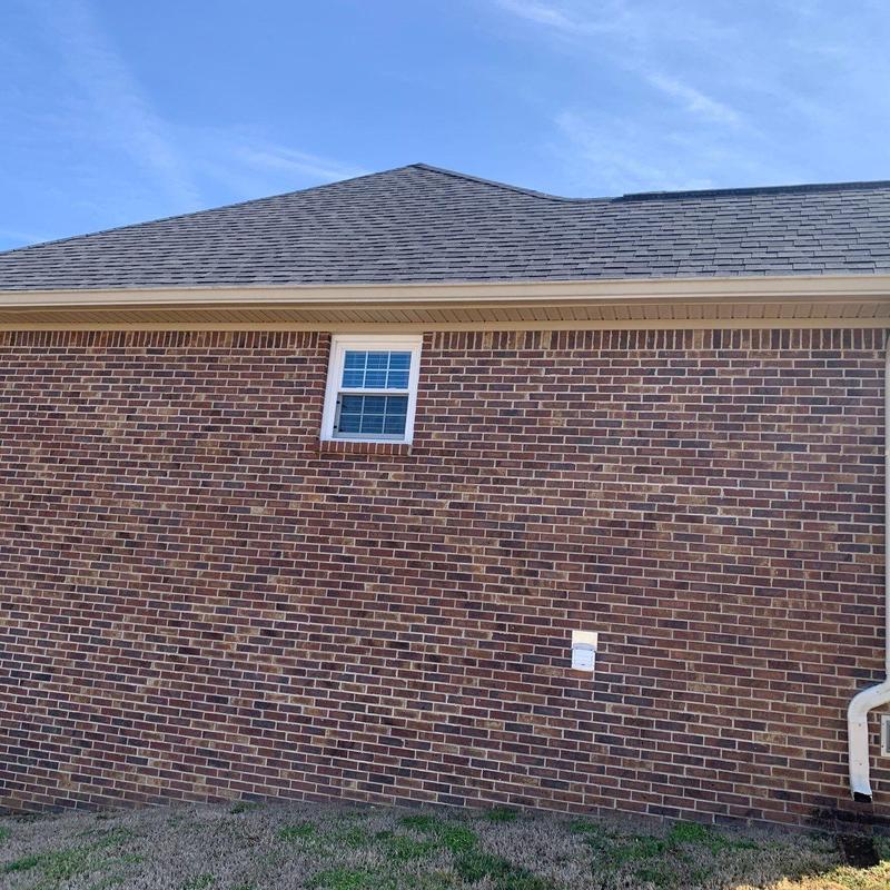 Asphalt shingle roof with gutter and brick wall