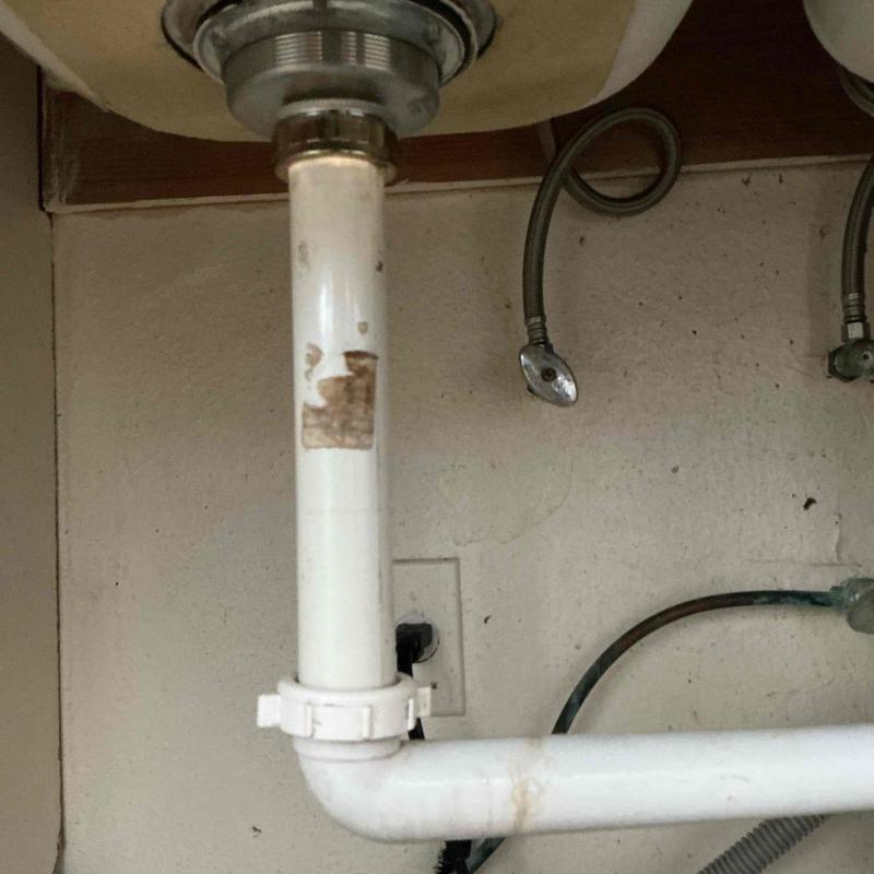 Kitchen sink basket strainer and PVC drain pipe under sink