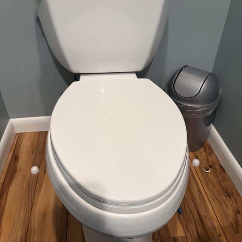 Toilet installation with waste line access on hardwood floor
