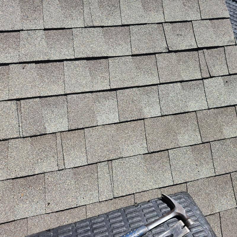 Asphalt roof shingles with minor storm damage near hammer